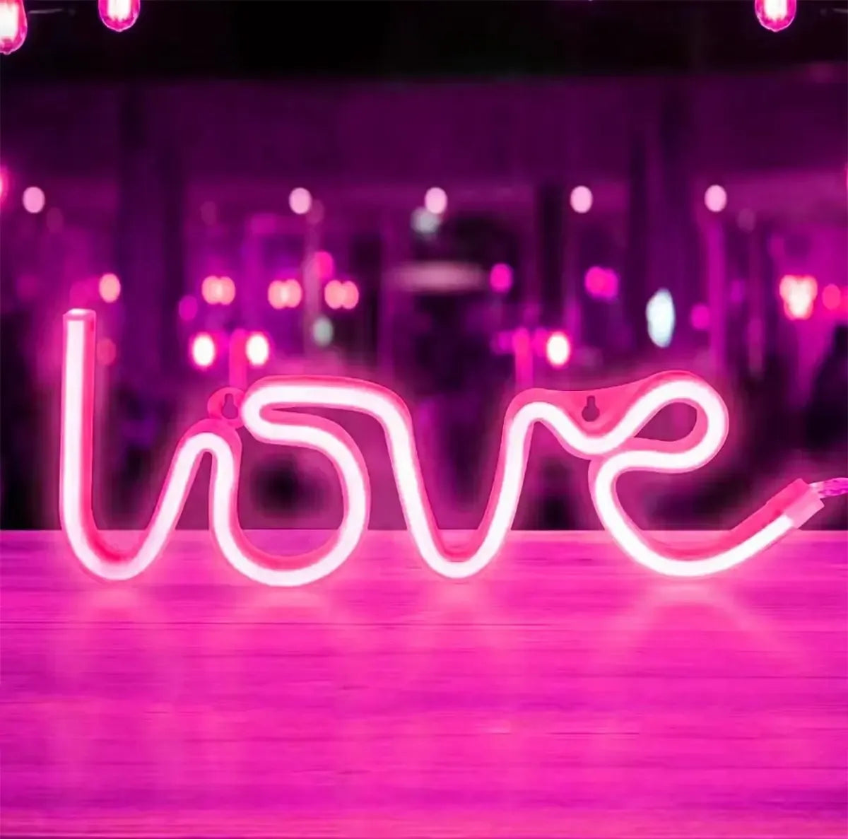 Violetinė LED dekoratyvinė lempa LOVE su šviesos efektu, namų ar renginių apšvietimui, švelni ir žaisminga dekoracija.