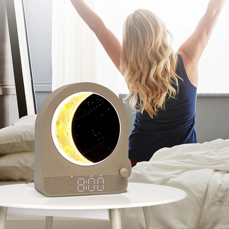 Šviesus „Moon“ elektrinis laikrodis-žadintuvas su moderniu dizainu ir apšvietimu, matomas iš priekio.