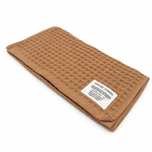 Rudos spalvos medvilninis rankšluostis, 34 × 74 cm, korio tipo, švelnus ir patvarus rankšluostis namų naudojimui.