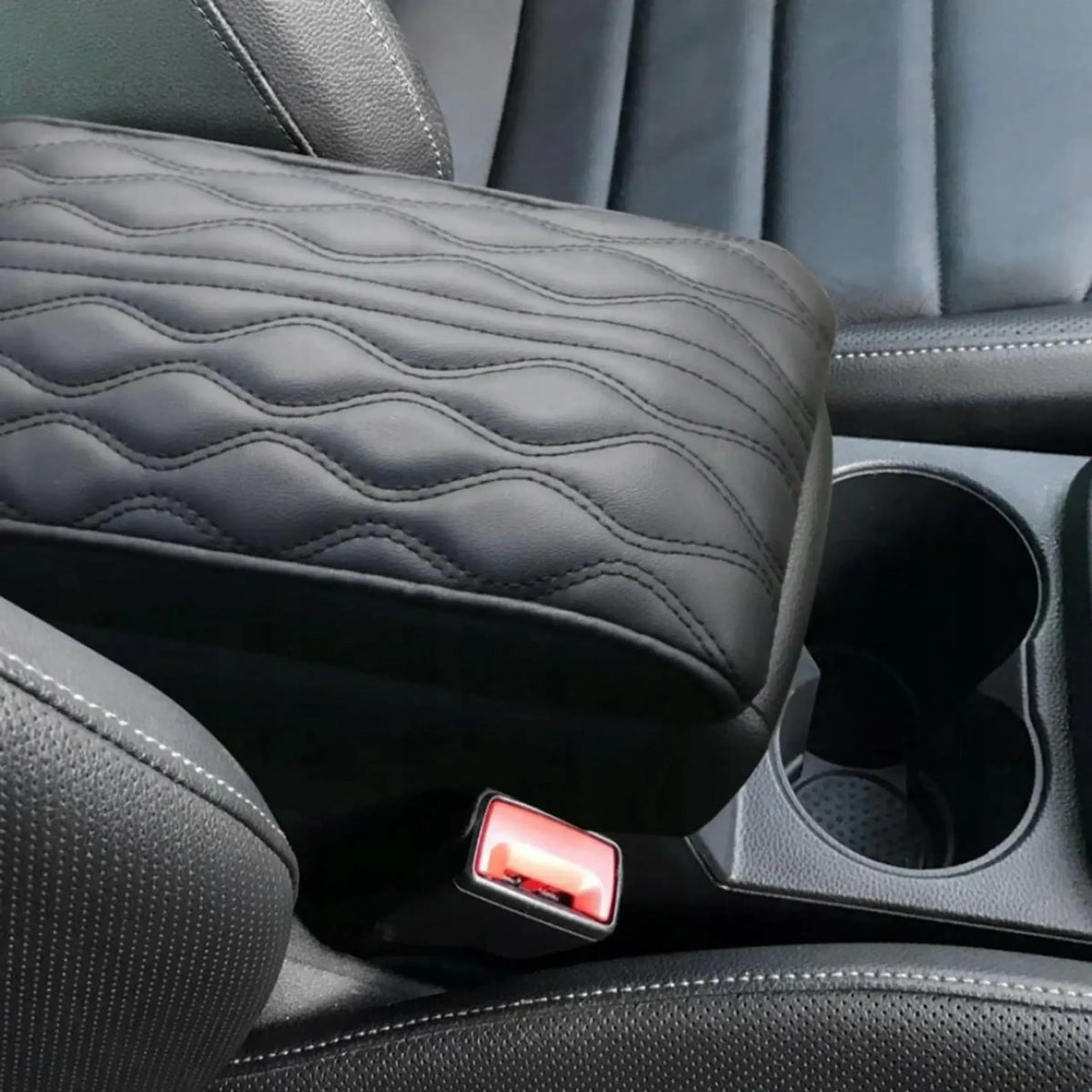 Automobilio porankio pagalvė, patogi ir ergonomiška, matoma iš arti, tamsios spalvos, skirta komfortui vairuojant.