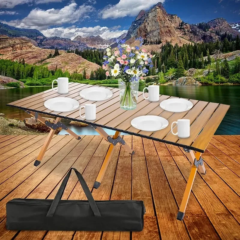 Sulankstomas iškylų stalas 120x60 cm su mediniu paviršiumi ir metalinėmis kojomis, tinkamas lauko iškyloms ir poilsiui.