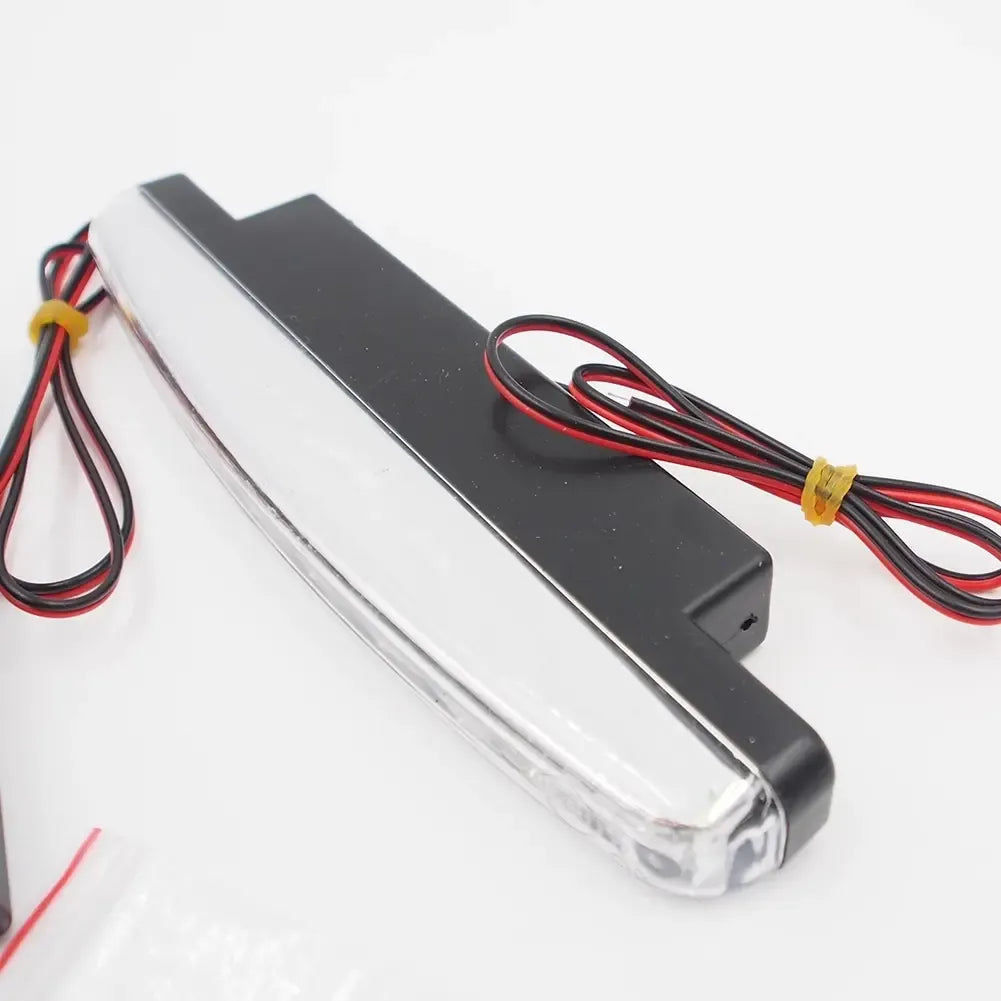 Universalūs LED dienos žibintai automobiliui, aiškiai matomi, su moderniu dizainu ir ryškiu apšvietimu.