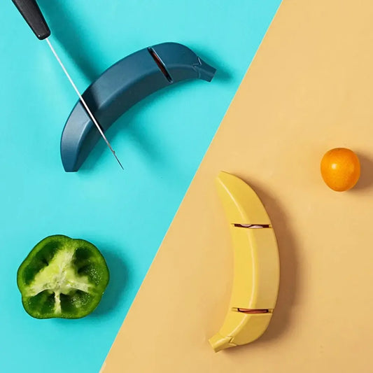 Peilių galąstuvas Banana, juodas ir kompaktiškas, su dantytomis šlifavimo dalimis, skirtas peilių aštrinimui namuose.